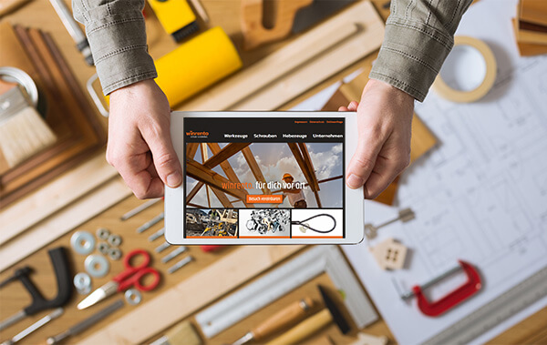 winrento - einfach. handwerken. Handwerker hält Tablet in der Hand.